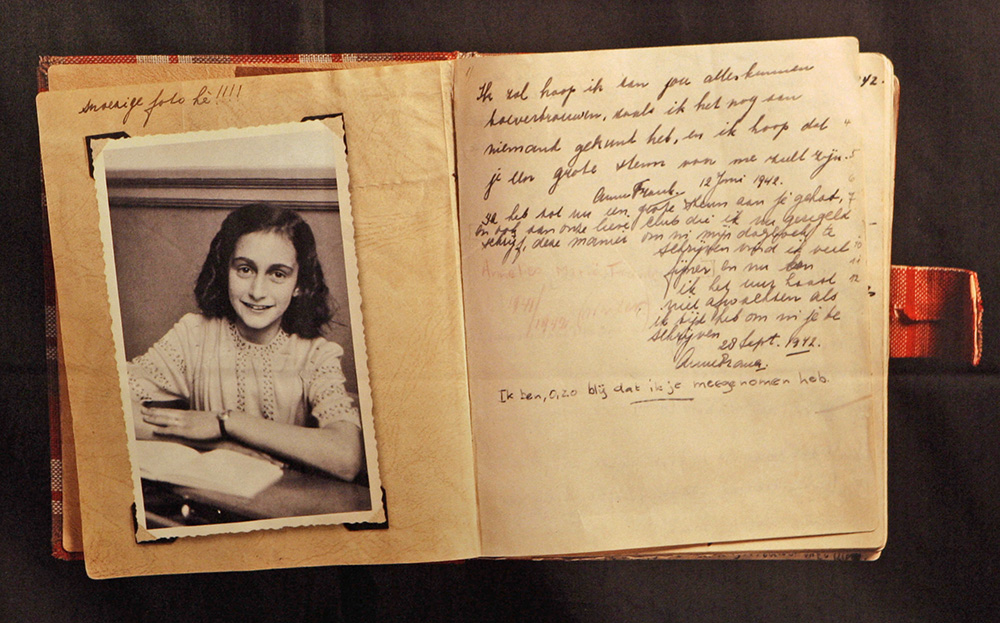 FILE - This June 12, 2009 file photo, shows a photo of Anne Frank at the opening of the exhibition: "Anne Frank, a History for Today", at the Westerbork Remembrance Centre in Hooghalen, northeast Netherlands. A new study by the Anne Frank House museum in Amsterdam said Friday, Dec. 16, 2016, there is no conclusive evidence that the Jewish diarist and her family were betrayed to the Netherlands’ German occupiers during World War II, leading to their arrest and deportation. (AP Photo/Bas Czerwinski, File)